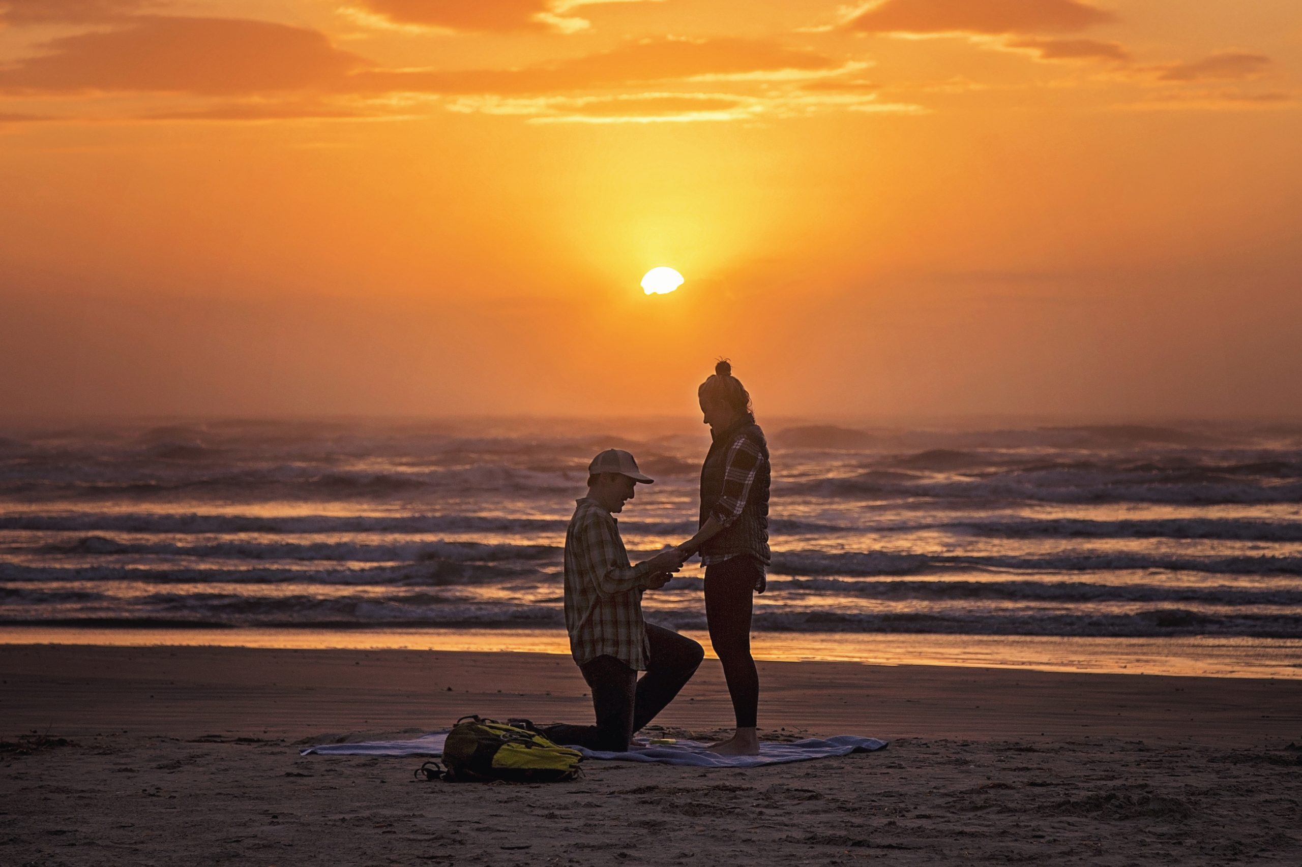 guy proposing by the beach to his girlfriend