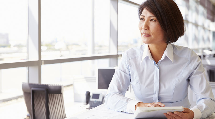 Asian woman in an office wearing a white long sleeves